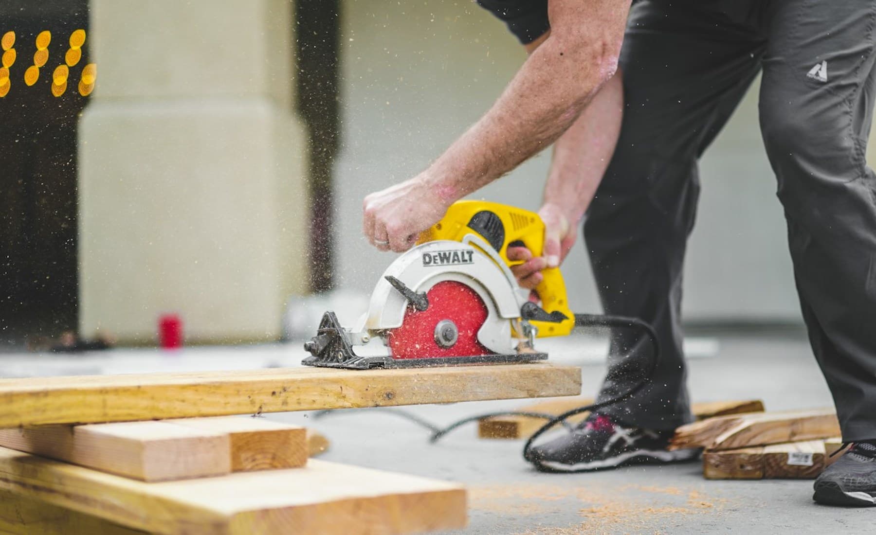 Representative carpenter cutting lumber during deck construction